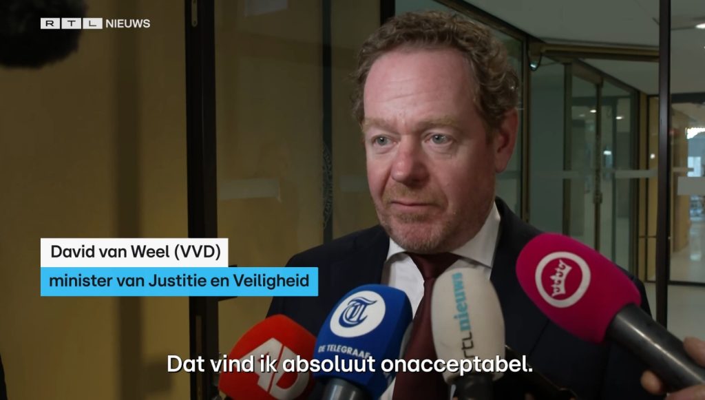 David van Weel (VVD) minister of Justice and Security being interviewed, several microphones in front of him, RTL Nieuws logo in background
